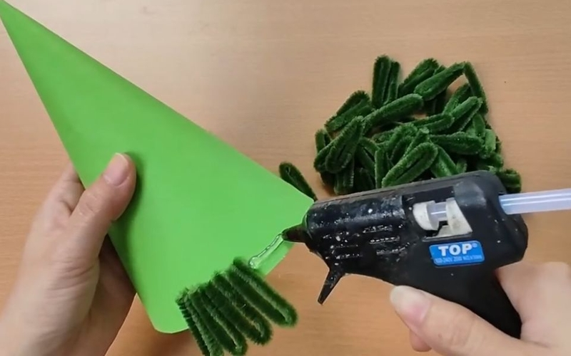 Gắn tán lá vào thân ứng dụng keo nến trong cách làm đồ trang trí Noel đơn giản tại nhà Gắn tán lá vào thân ứng dụng keo nến trong cách làm đồ trang trí Noel đơn giản tại nhà